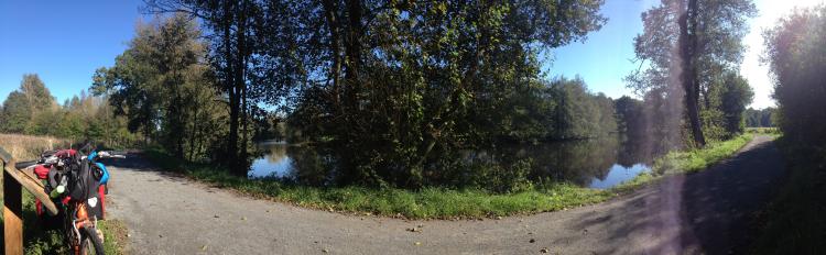 Beautiful, sunny riverside path, with my tiger bike propped up against a fence