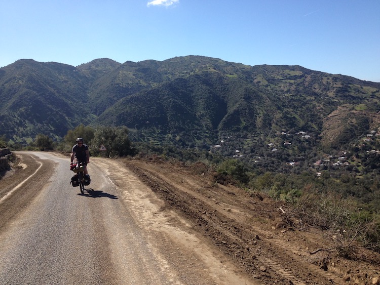 Nico cycling slowly up a small mountain road.