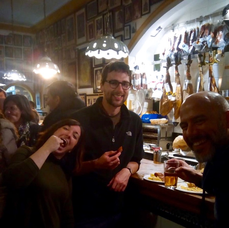 Paloma, Dan and Julio drinking beer and eating traditional Sevillian food in a local bar. Santos is taking the photo.