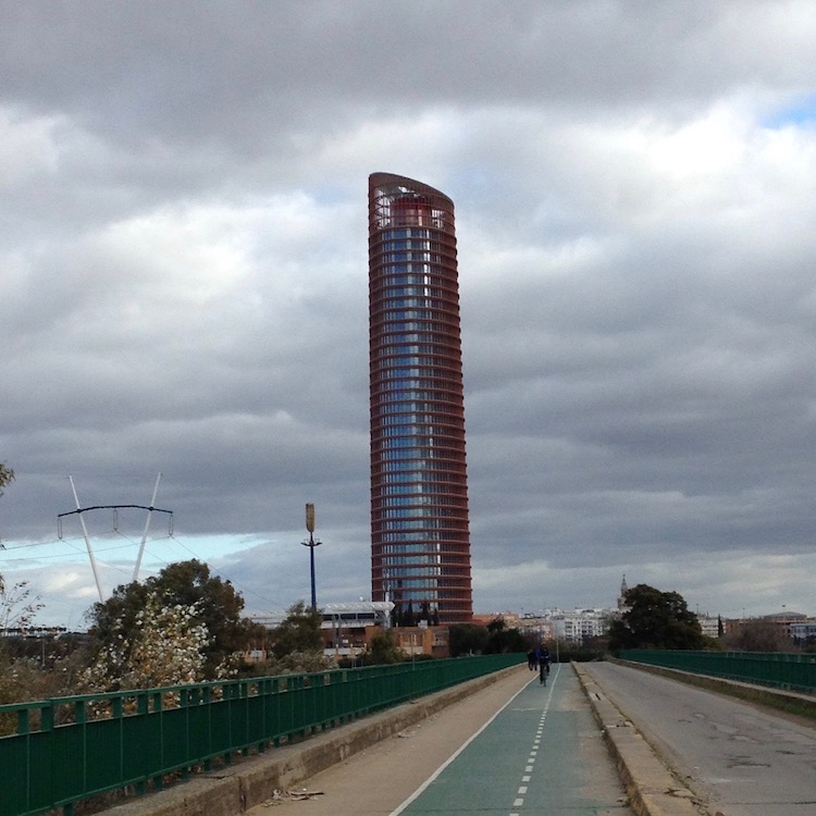 A tall, cylindrical building in Seville, closely resembling a tube of lipstick: The top is slanted and open-air, and a red protrusion can be seen inside.